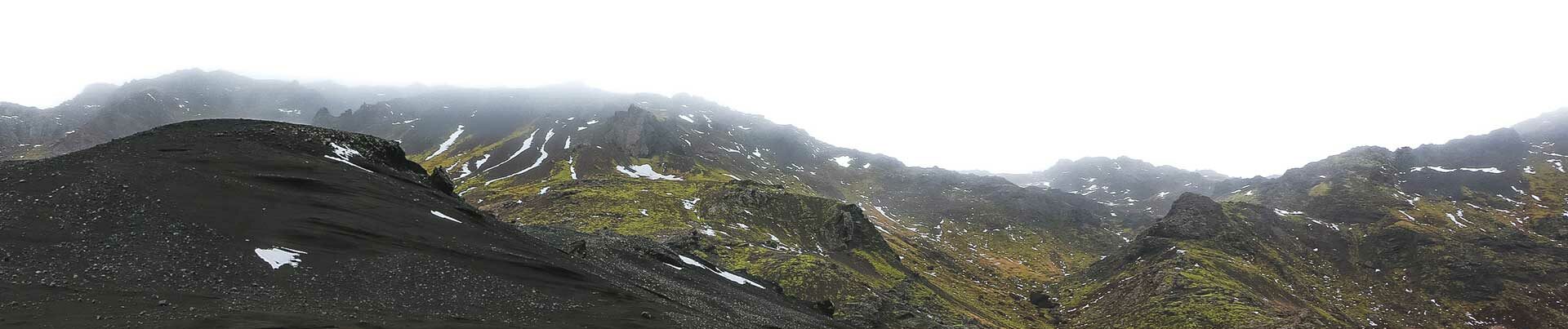 Montagnes vertes, cendres et ciel blanc